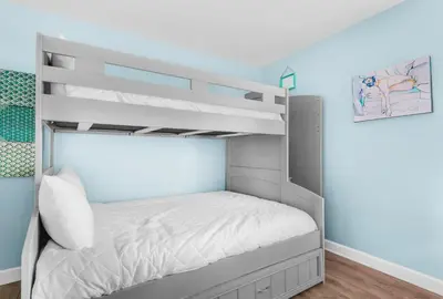a bunk bed in a bedroom with blue walls at Horizon South 8B2- Sunshine Gardens in Panama City Beach