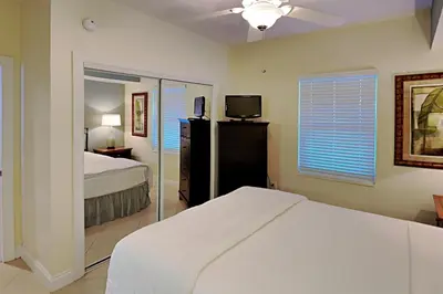 a bedroom with a bed and a tv and a window at Palazzo #1407 in Panama City Beach