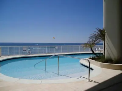 a large swimming pool with the ocean in the background at Palazzo #1407 in Panama City Beach