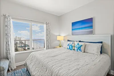a white bedroom with a large bed with a window at Modern Beachfront Condo on the Beach Sleeps 6! by Dolce Vita Getaways PCB in Panama City Beach