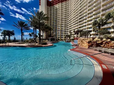 a large swimming pool in front of a large building at Modern Beachfront Condo on the Beach Sleeps 6! by Dolce Vita Getaways PCB in Panama City Beach