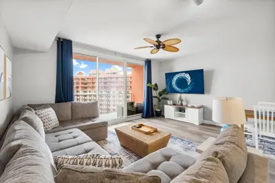 a living room with a couch and a ceiling fan at Modern Beachfront Condo on the Beach Sleeps 6! by Dolce Vita Getaways PCB in Panama City Beach