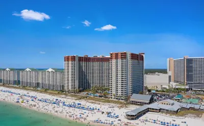 a view of a beach with people and buildings at Modern Beachfront Condo on the Beach Sleeps 6! by Dolce Vita Getaways PCB in Panama City Beach