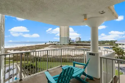 a balcony with two chairs and a view of the beach at Top of the Gulf 410 Beach Front Condo - Renovated! in Panama City Beach