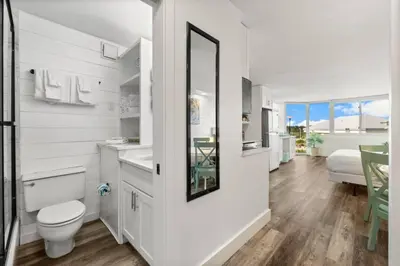 a white bathroom with a toilet and a sink at Top of the Gulf 410 Beach Front Condo - Renovated! in Panama City Beach