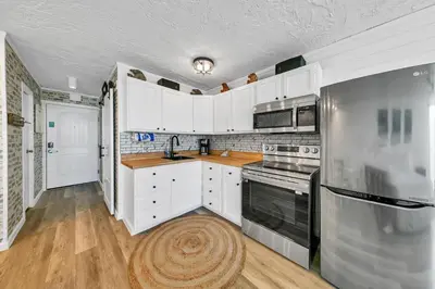 a kitchen with white cabinets and black appliances at Top of the Gulf 811 in Panama City Beach
