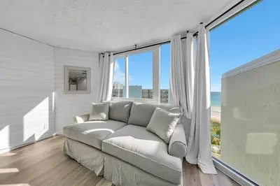 a living room with a couch and a large window at Top of the Gulf 811 in Panama City Beach