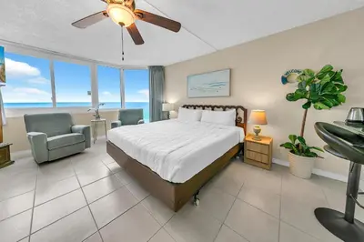 a bedroom with a bed and a couch and a chair at Top of the Gulf 825 in Panama City Beach