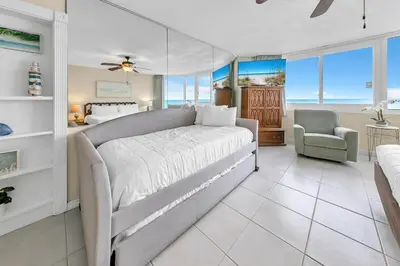 a bedroom with a bed and a couch and a chair at Top of the Gulf 825 in Panama City Beach