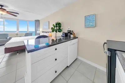 a bedroom with a bed and a kitchen with a sink at Top of the Gulf 825 in Panama City Beach