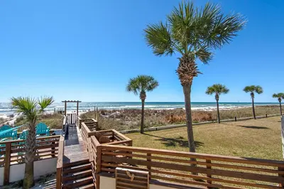 a boardwalk leading to the beach with palm trees at Top of the Gulf 825 in Panama City Beach