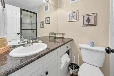 a white bathroom with a sink and a toilet at Top of the Gulf 825 in Panama City Beach