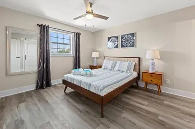 a bedroom with a bed and a ceiling fan at Welcome to Dolphin Fun B, BRAND NEW Duplex Walk to the Beach in Panama City Beach