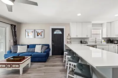 a kitchen and a living room with a blue couch at Welcome to Dolphin Fun B, BRAND NEW Duplex Walk to the Beach in Panama City Beach