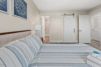 a bedroom with a bed and a closet at Welcome to Dolphin Fun B, BRAND NEW Duplex Walk to the Beach in Panama City Beach