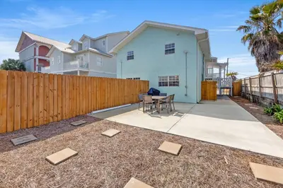 a backyard with a fence and a table and chairs at Welcome to Dolphin Fun B, BRAND NEW Duplex Walk to the Beach in Panama City Beach