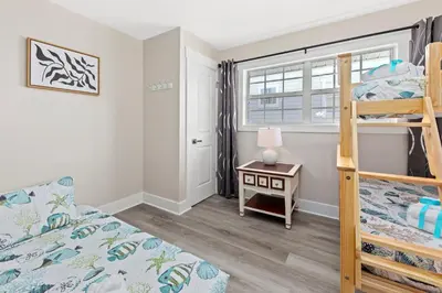 a bedroom with a bunk bed and a desk at Welcome to Dolphin Fun B, BRAND NEW Duplex Walk to the Beach in Panama City Beach