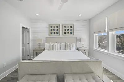 a white bedroom with a large bed and two windows at La Joya Azul in Inlet Beach