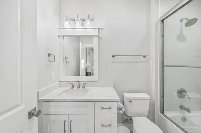 a white bathroom with a sink and a toilet at La Joya Azul in Inlet Beach