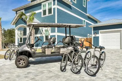 a golf cart with bikes parked in front of a house at La Joya Azul in Inlet Beach