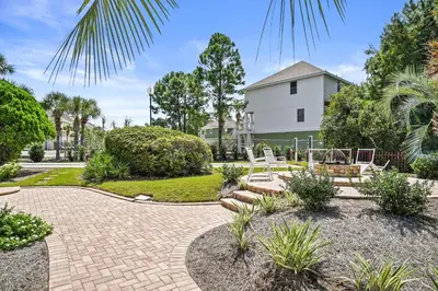 a patio with chairs and trees and a house at St Thomas Square by Panhandle Getaways in Panama City Beach