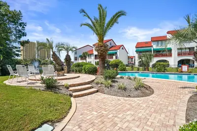 a resort with a swimming pool and palm trees at St Thomas Square by Panhandle Getaways in Panama City Beach