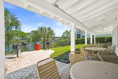a patio with tables and chairs and a grill at St Thomas Square by Panhandle Getaways in Panama City Beach