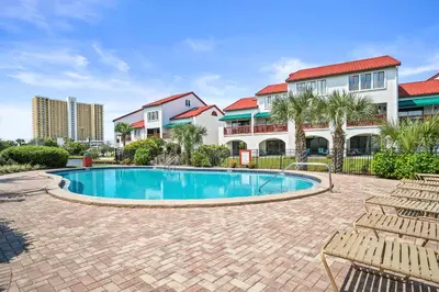 a swimming pool in a courtyard with chairs and condos at St Thomas Square by Panhandle Getaways in Panama City Beach