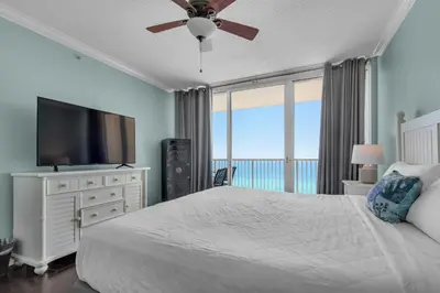 a bedroom with a large bed and a flat screen tv at Majestic Beach Towers 1-1302 in Panama City Beach