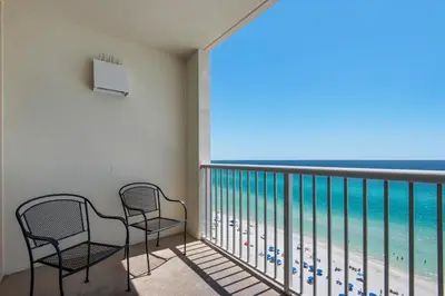 a balcony with two chairs and a view of the ocean at Majestic Beach Towers 1-1302 in Panama City Beach