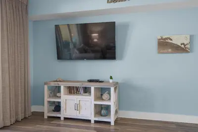 a living room with a tv on a wall at Calypso 3-708 in Panama City Beach