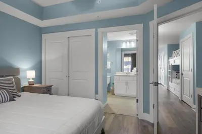 a bedroom with blue walls and a white bed at Calypso 3-708 in Panama City Beach