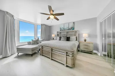 a bedroom with a bed and a ceiling fan at Emerald Beach 1036 - Turquoise Turtle in Panama City Beach
