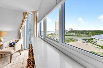 a living room with a large window and a chair at Top of the Gulf 808- Gulf Coast Getaway in Panama City Beach
