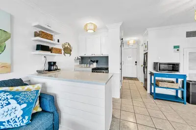 a kitchen and living room with a blue couch at Top of the Gulf 808- Gulf Coast Getaway in Panama City Beach