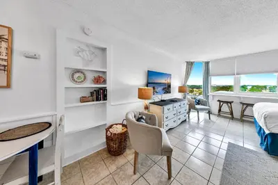 a bedroom with a bed and a desk and a table at Top of the Gulf 808- Gulf Coast Getaway in Panama City Beach