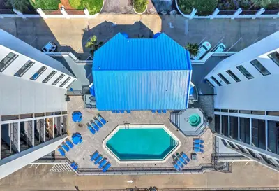an overhead view of a pool with chairs and a building at AquaVista Beach Resort by Sand Seeker Vacations in Panama City Beach