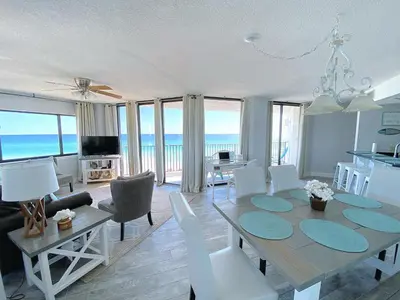 a dining room and living room with a table and chairs at AquaVista Beach Resort by Sand Seeker Vacations in Panama City Beach