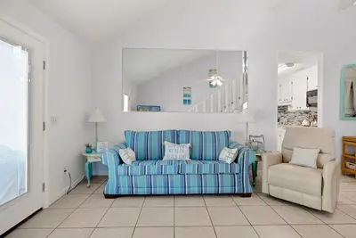 a living room with a blue couch and a chair at Chic Townhouse Steps to the Beach Outdoor Pools in Panama City Beach