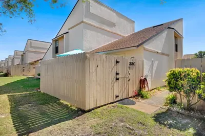 a wooden fence in front of a house at Chic Townhouse Steps to the Beach Outdoor Pools in Panama City Beach