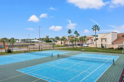 a tennis court with a net on it at Chic Townhouse Steps to the Beach Outdoor Pools in Panama City Beach