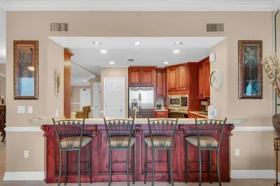 a kitchen with a island with bar stools at Hidden Dunes 1803 in Panama City Beach
