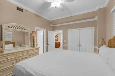 a bedroom with a large white bed and a mirror at Hidden Dunes 1803 in Panama City Beach