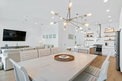 a dining room and kitchen with a table and chairs at Beach House with Private Pool - Elevated Escape by Panhandle Getaways in Panama City Beach