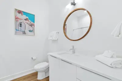 a white bathroom with a sink and a mirror at Beach House with Private Pool - Elevated Escape by Panhandle Getaways in Panama City Beach