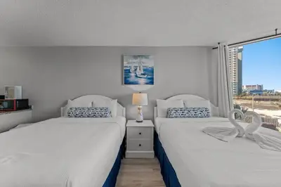 two beds in a bedroom with a window at Top of The Gulf 306 in Panama City Beach