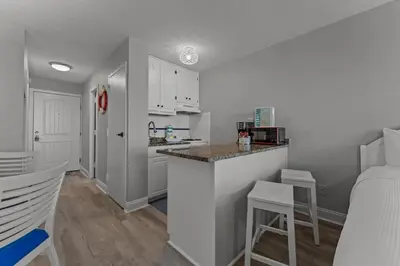 a kitchen with white cabinets and a counter top at Top of The Gulf 306 in Panama City Beach