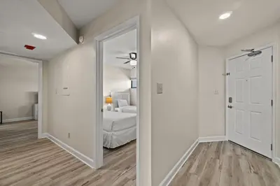 a white bedroom with a bed and a mirror at Aquavista 804E in Panama City Beach