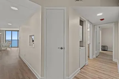 a hallway of a home with white walls and a door at Aquavista 804E in Panama City Beach