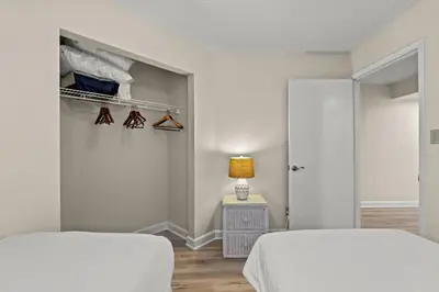 two beds in a room with a closet at Aquavista 804E in Panama City Beach